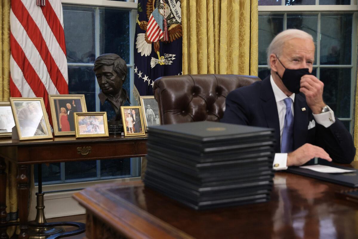 President Joe Biden prepares to sign a series of executive orders at the Resolute Desk in the Oval Office in Washington, on Jan. 20, 2021. (Chip Somodevilla/Getty Images)