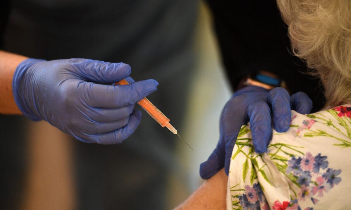 A resident receives a dose of the Oxford-AstraZeneca CCP virus vaccine at the Belong Wigan care home in Wigan, northwest England, on Jan. 21, 2021. (Oli Scarff/AFP via Getty Images)