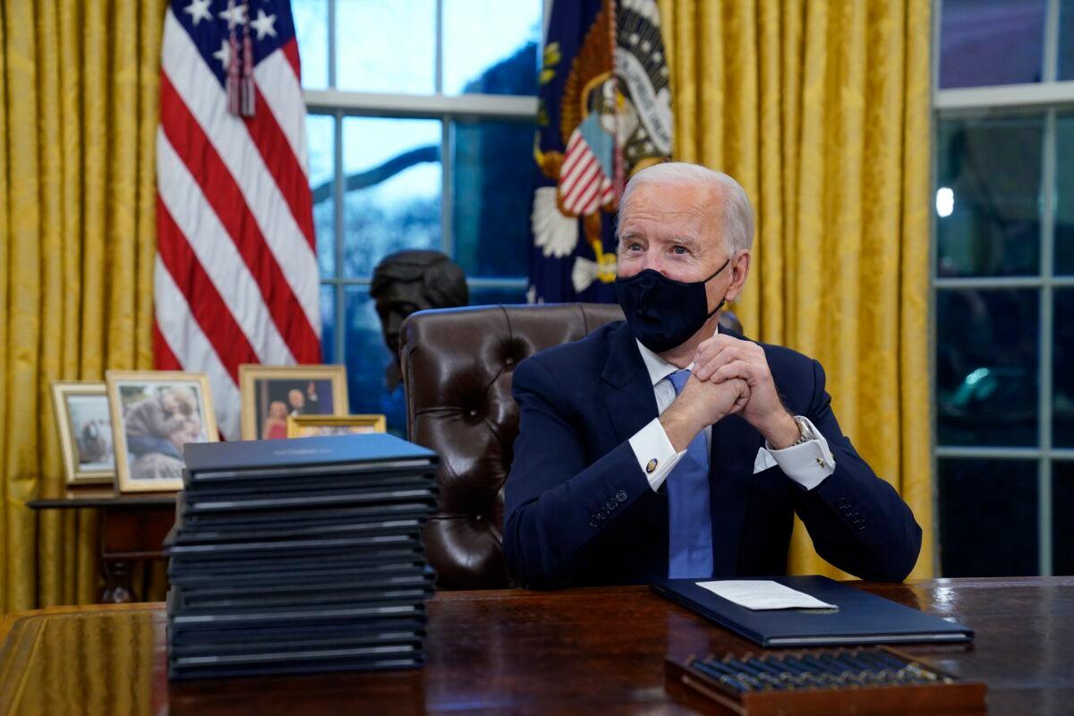 President Joe Biden waits to sign his first executive order in the Oval Office of the White House in Washington on Jan. 20, 2021. (Evan Vucci/AP Photo)