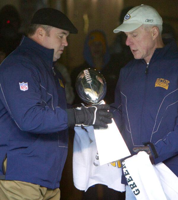 General manager, Ted Thompson (right), hands the Vince Lombardi Trophy to coach Mike McCarthy before walking onto the field for the "Return to Titletown" celebration at Lambeau Field in Green Bay, Wis., on Feb. 8, 2011. (Mike Roemer/AP Photo)