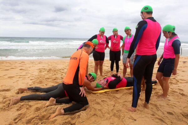 Instructor Brett Walker guides Garie Vanguard Surf Life Saving trainees as they perform a mock ocean rescue and resuscitation at Garie Beach in Sydney, Australia on Nov. 24, 2019. (Lisa Maree Williams/Getty Images)