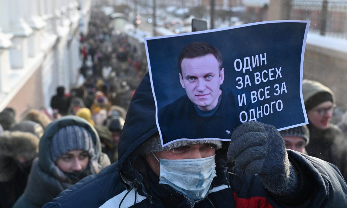 A man holds a placard reading "One for all, all for one" during a rally in support of jailed Russian opposition leader Alexei Navalny in Omsk, Russia, on Jan. 23, 2021. (Alexey Malgavko/Reuters)