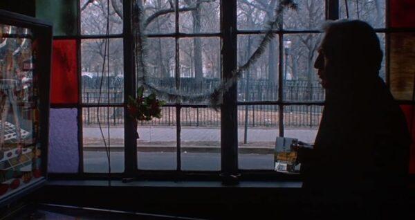 Lawyer Frank Galvin (Paul Newman) in a dark tavern, with a bleak winter view visible through a window. (Twentieth Century Fox)