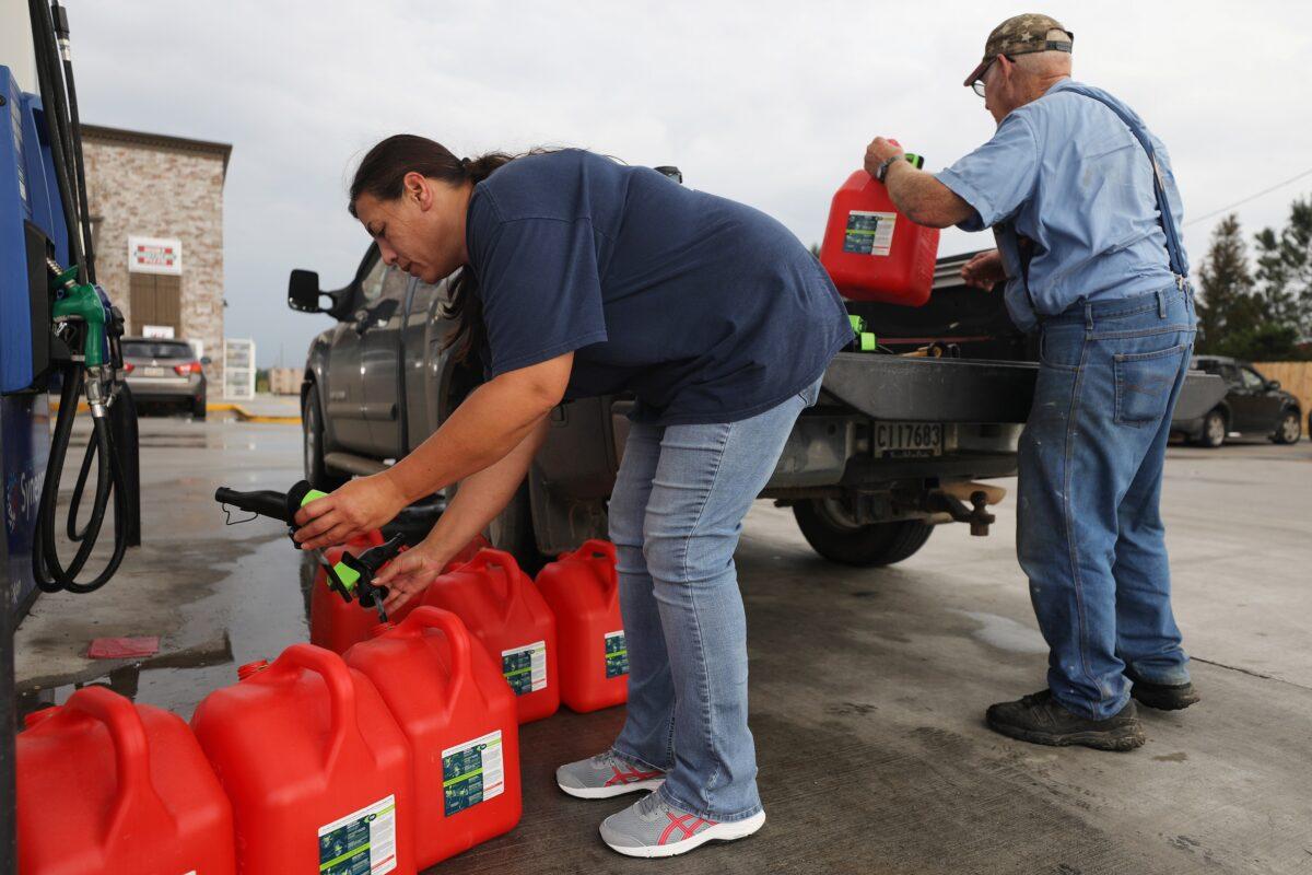 A man and woman place gas cans in their truck in Lacassine, La., on Oct. 8, 2020. (Mario Tama/Getty Images)