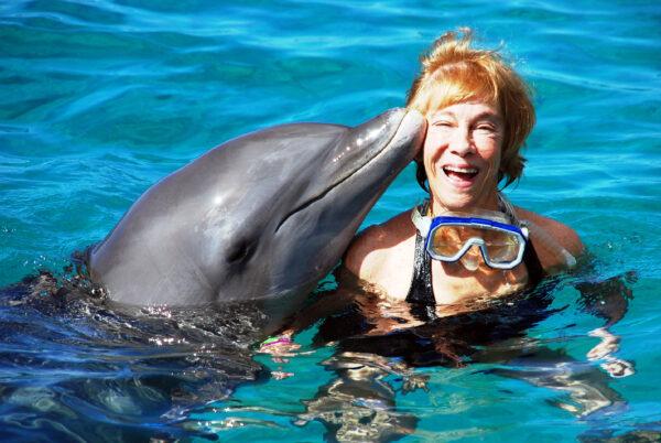 The author swims with Romeo the dolphin at the Dolphin Academy of Curaçao Sea Aquarium. (Courtesy of Victor Block)