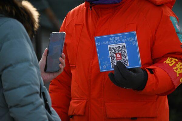 A woman uses her cellphone to scan a venue code before entering an outdoor ice rink in Beijing on Jan. 12, 2021. (WANG ZHAO/AFP via Getty Images)