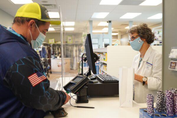 Pharmacist Cathy Lilienthal helps a customer at Brehme Drug in Manchester, Iowa, on Jan. 16, 2021. (Cara Ding/The Epoch Times)