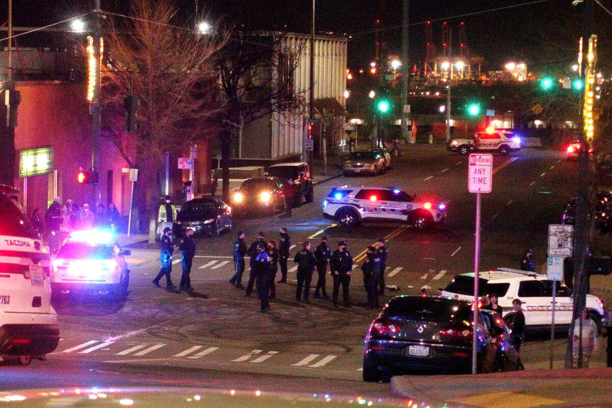 Tacoma Police and other law enforcement officers stand in an intersection near the site of a car crash in Tacoma, Wash., on Jan. 23, 2021. (Ted S. Warren/AP Photo)