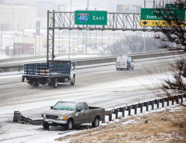 A pickup truck sits on the side of eastbound I-480 after an accident on slick roads in Omaha, Neb., on Jan. 25, 2021. (Chris Machian/Omaha World-Herald via AP)