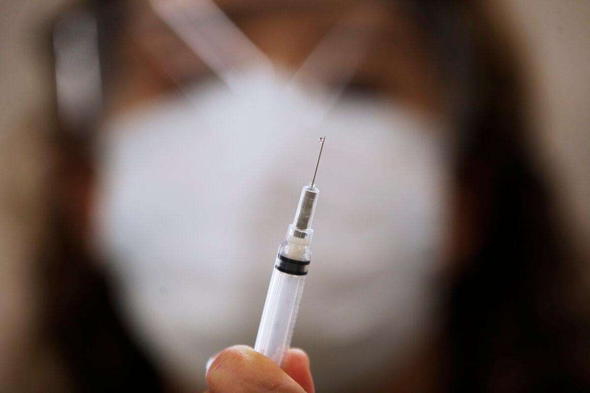 A public health nurse prepares dilutant for the COVID-19 vaccine in the COVID-19 vaccination clinic at the Health Sciences Centre in Winnipeg, Canada, on Dec. 16, 2020. (John Woods/The Canadian Press)