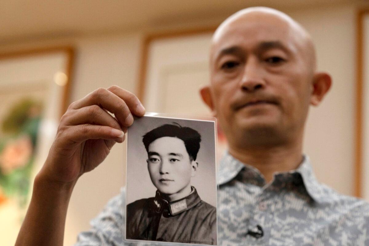 Zhang Hai holds up a photo of his father taken in his youth during an interview in Shenzhen in southern China's Guangdong Province on Oct. 16, 2020. (Ng Han Guan/AP Photo)