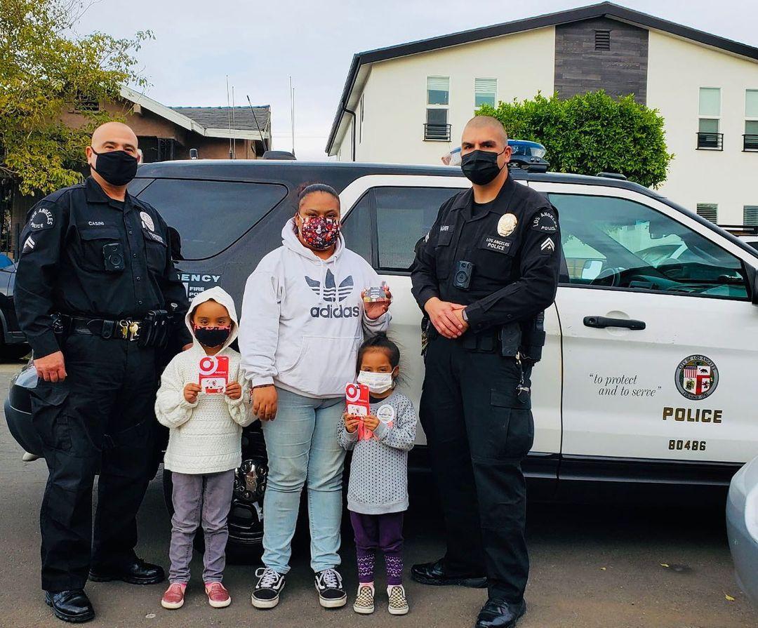 Nancy Colín with two of her daughters and LAPD officers after most of their clothes were stolen when their car was broken into. (Courtesy of <a href="https://badgeofheart.org/">Badge of Heart</a>)