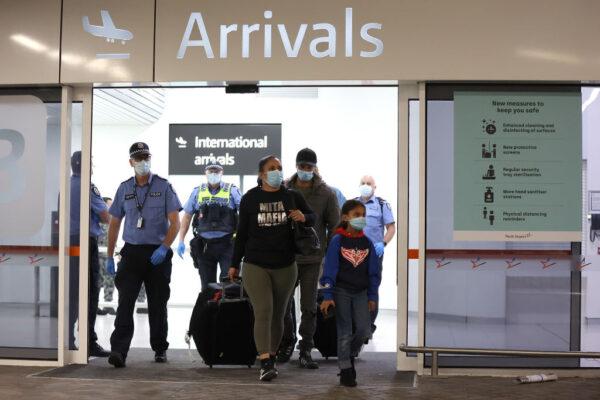 Passengers from Qantas flight QF583 are escorted to Transperth buses by Police Officers after being processed following their arrival at Perth Airport from Sydney, before being driven to a CBD hotel for quarantining in Perth, Australia, on Oct. 19, 2020. ( Paul Kane/Getty Images)