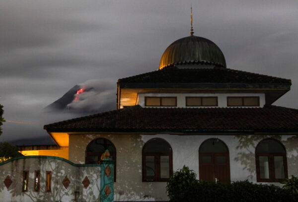 Hot lava runs down from the crater of Mount Merapi, partially seen behind a mosque in Sleman, Indonesia, on, Jan. 26, 2021. (Slamet Riyadi/AP Photo)