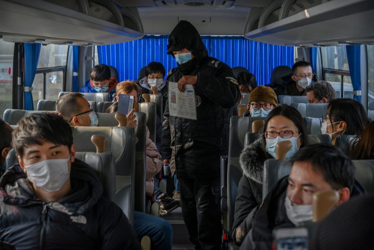 A Chinese security guard wears a mask to protect against COVID-19 as media and staff scan their health code before visiting the National Speed Skating Oval during an organized tour in Beijing on Jan. 22, 2021. (Kevin Frayer/Getty Images)