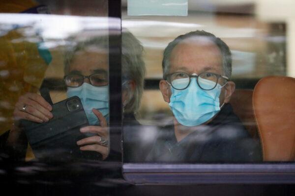 Peter Ben Embarek and Marion Koopmans, members of the World Health Organization (WHO) team tasked with investigating the origins of the coronavirus disease (COVID-19) pandemic, sit on a bus as they leave their quarantine hotel in Wuhan, Hubei Province, China, on Jan. 28, 2021. (Reuters/Thomas Peter)