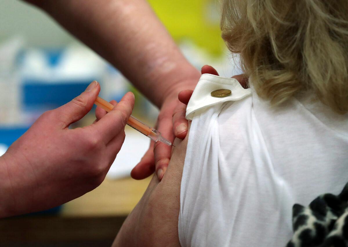 Mary Williams receives an injection of the Oxford/AstraZeneca vaccine at the mass vaccination center in Newcastle Upon Tyne, England, on Jan. 11, 2021. (Scott Heppell/AP Photo)