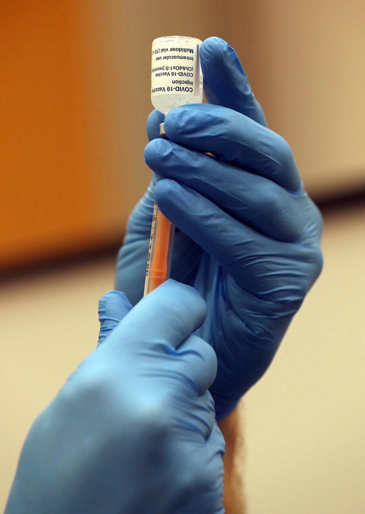 A paramedic draws a syringe of the Oxford/AstraZeneca vaccine at the mass vaccination center in Newcastle Upon Tyne, England, on Jan. 11, 2021. (Scott Heppell/AP Photo)