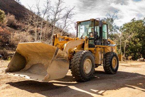 Pat Ogle operates a bulldozer to clear debris in Williams Canyon, Calif., on Jan. 28, 2021. (John Fredricks/The Epoch Times)