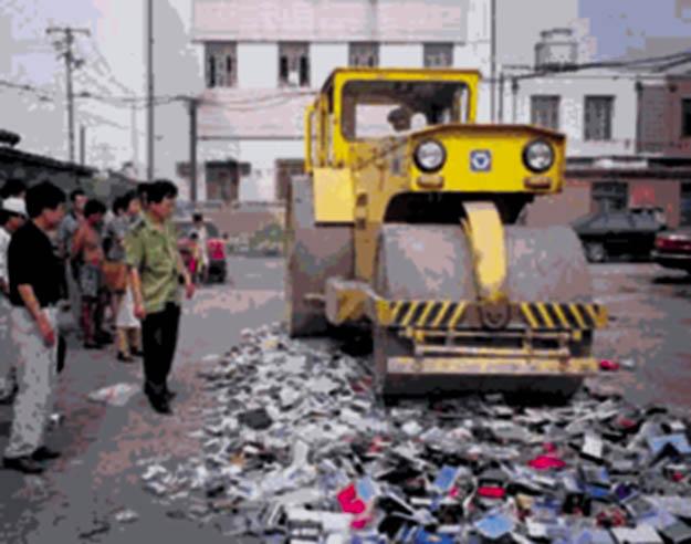 Falun Gong books being crushed under a road roller during the 1999 nationwide destruction of the spiritual practice's publications and materials. (<a href="https://en.wikipedia.org/wiki/File:Destruction_d'ouvrages_du_Falun_Gong_lors_de_la_r%C3%A9pression_de_1999_en_Chine.jpg">Minghui.org</a>/CC0 1.0)