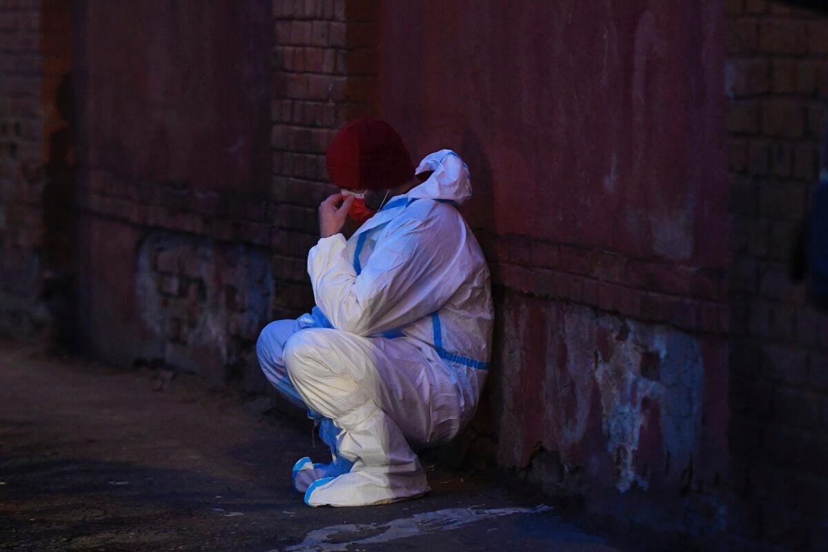 An emergency paramedic takes a moments rest outside a hospital after a fire broke out on the ground floor, Romania, on Jan. 29, 2021. (Andreea Alexandru/AP Photo)