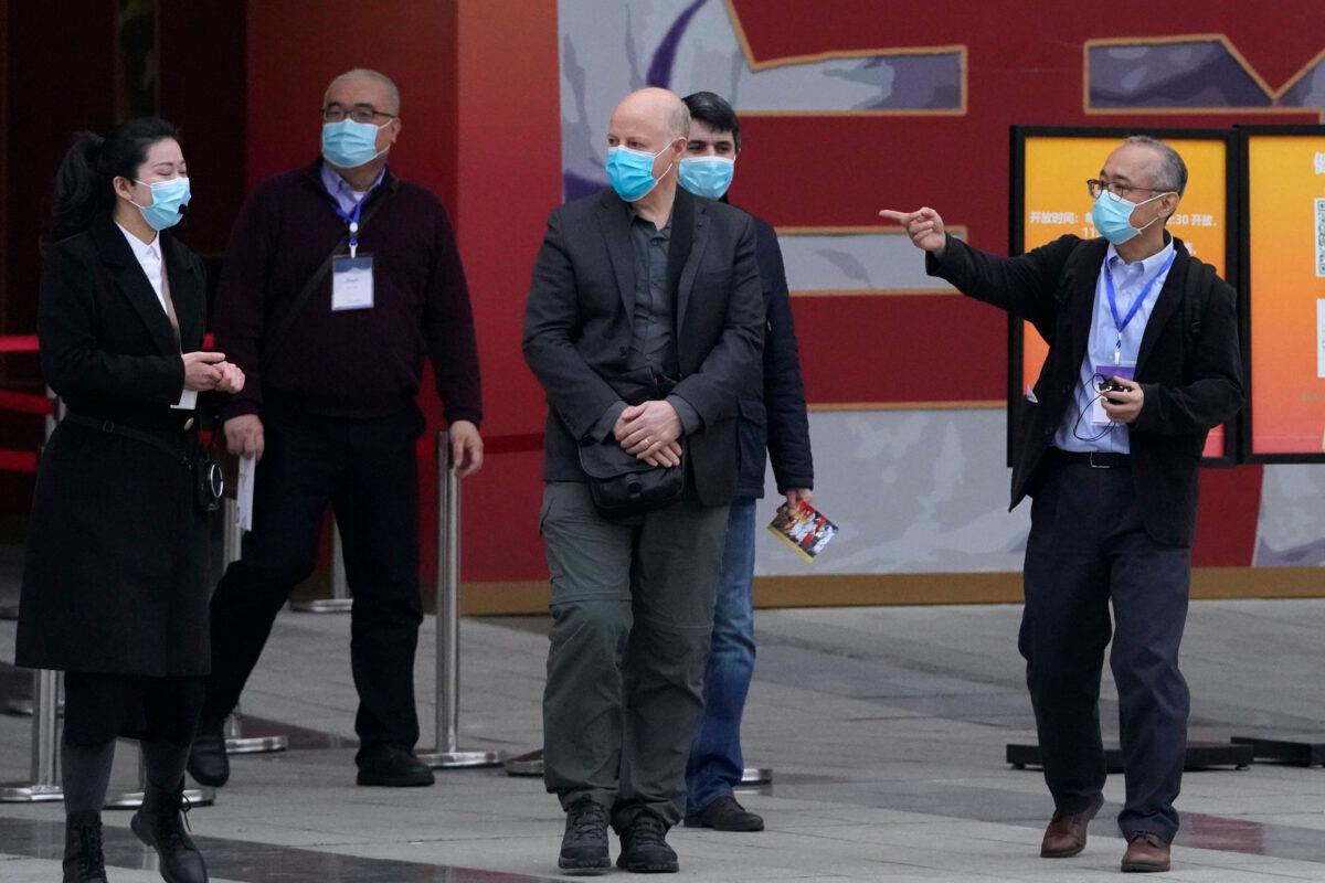 Members of the World Health Organization team including Ken Maeda, right, Peter Daszak, third from left, and Vladimir Dedkov, fourth from left, leave after attending an exhibition about the fight against the coronavirus in Wuhan, Hubei Province, China, on Jan. 30, 2021. (Ng Han Guan/AP)