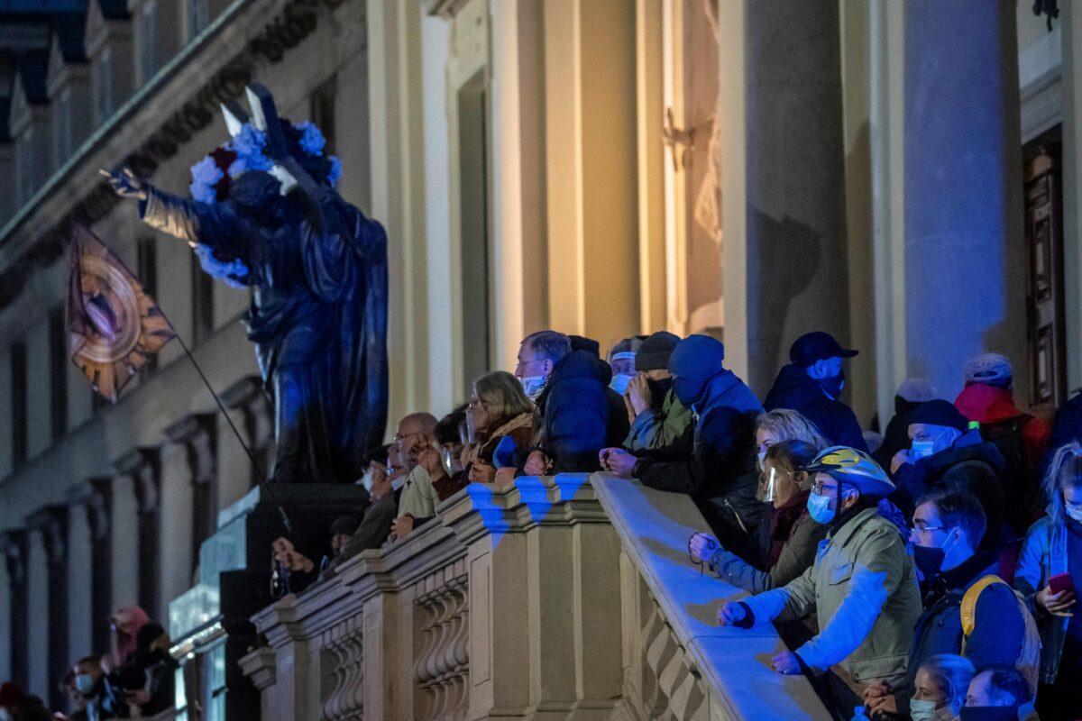 Believers pray on the stairs of the Holy Cross Church as protesters take part in a demonstration against tightening Poland's abortion law, in Warsaw, Poland, on Oct. 30, 2020. (Wojtek Radwanski/AFP via Getty Images)