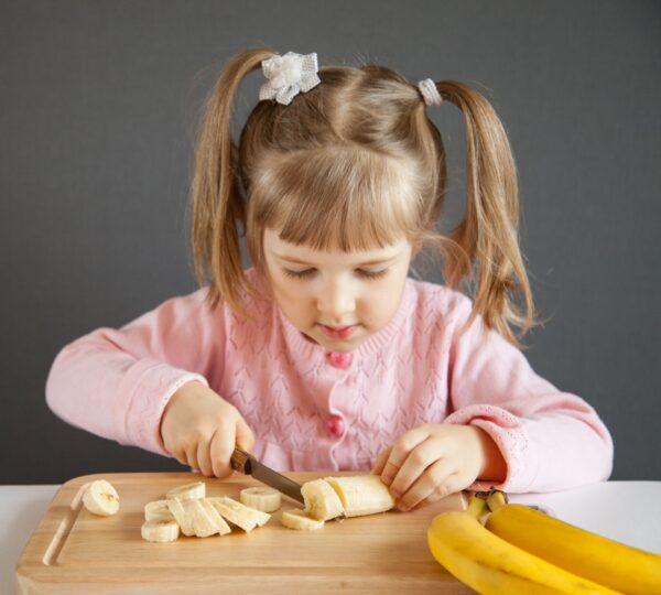 Participating in age-appropriate risk-taking activities—such as learning knife skills—helps children develop coping skills for resilience. (Maryna Pleshkun/Shutterstock)