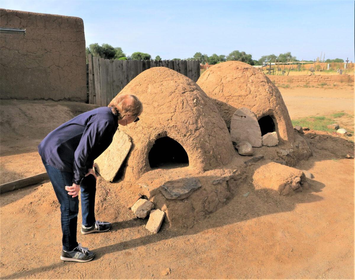 A visitor examines the "hornos" where Native Americans still bake bread in Taos, N.M. (Courtesy of Victor Block)