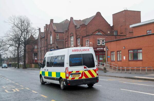 An ambulance rides in front of Bedford Hospital as Britain's centenarian fundraiser Captain Sir Tom Moore is taken to a hospital after testing positive for coronavirus disease (COVID-19) during treatment for pneumonia, in Bedford, Britain, on Feb. 1, 2021. (Andrew Boyers/Reuters)