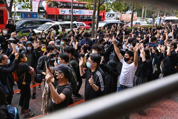  Hongkongers hold up five fingers in support of 47 pro-democracy activists charged under the national security law in Hong Kong on March 1, 2021. (Sung Pi-lung/The Epoch Times)