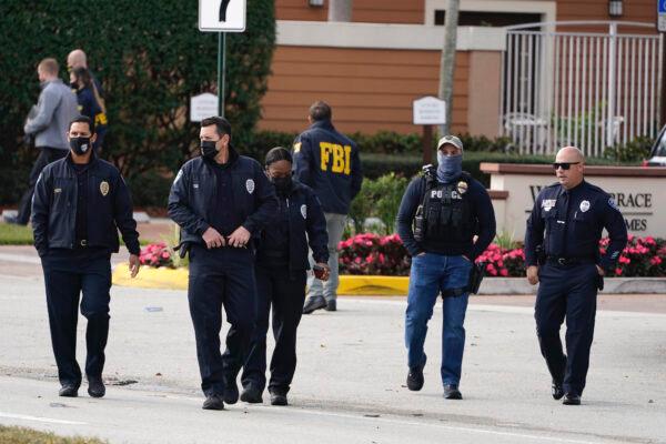 Law enforcement officers walk near the entrance to an apartment complex where a shooting wounded several FBI agents while serving an arrest warrant, in Sunrise, Fla., on Feb. 2, 2021. (Marta Lavandier/AP Photo)
