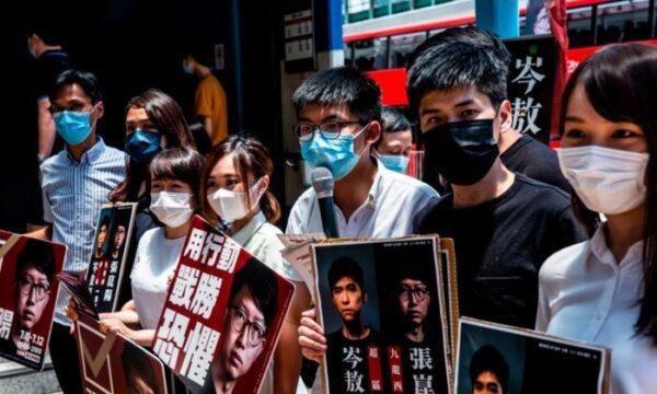 (L-R) Pro-democracy activists Eddie Chu, Gwyneth Ho, Leung Hoi-ching, Tiffany Yuen, Joshua Wong, Lester Shum, and Agnes Chow campaign during primary elections in Hong Kong on July 12, 2020. (Issac Lawrence/AFP via Getty Images)