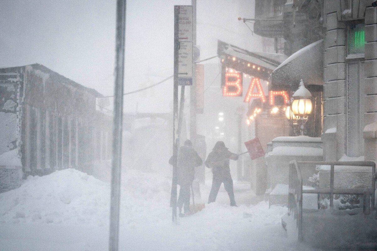 Workers shovel snow from their restaurant and bar entrance in midtown, New York City during a snowstorm, in New York, on Feb. 1, 2021. (Wong Maye-E/AP Photo)