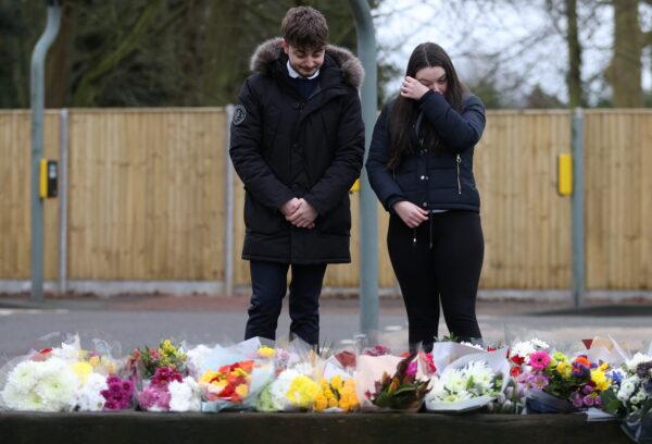 People look at flowers left near to the residence of Captain Sir Tom Moore, after his family announced that the centenarian fundraiser died, in Marston Moretaine near Milton Keynes, Britain, on Feb. 3, 2021. (Hannah McKay/Reuters)