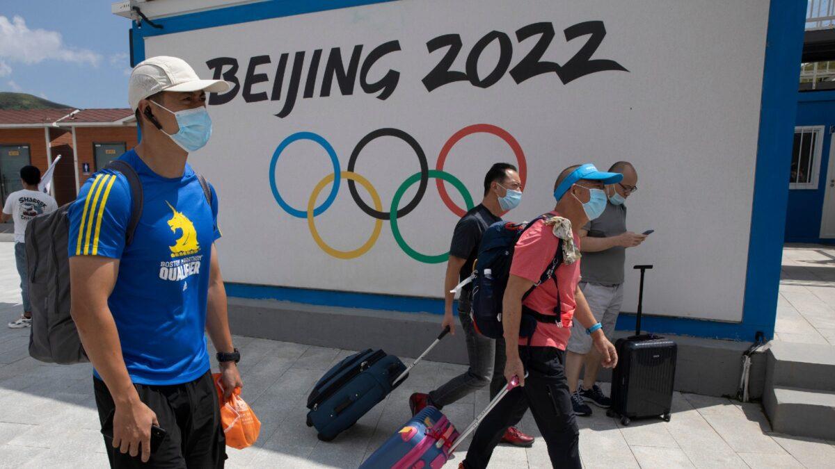 Visitors to Chongli, one of the venues for the Beijing 2022 Winter Olympics, pass by the Olympics logo in Chongli in Hebei Province, China, on Aug. 13, 2020. (Ng Han Guan/AP Photo)