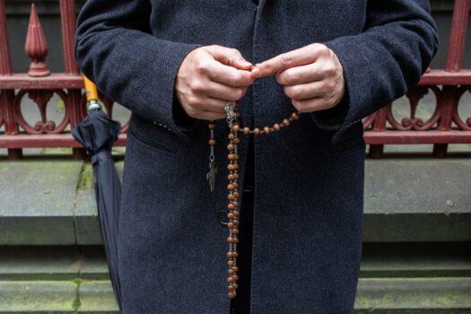 A man holding rosary beads outside the Supreme court of Victoria in Melbourne on June 5, 2019. (Asanka Brendon Ratnayake/AFP via Getty Images)