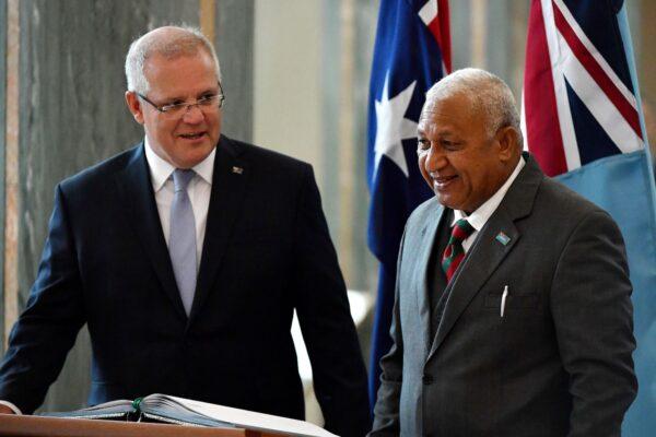 Australia's Prime Minister Scott Morrison (L) invites his Fijian counterpart Frank Bainimarama to sign a visitors book at Parliament House in Canberra on September 16, 2019. (Mick Tsikas/AFP via Getty Images)