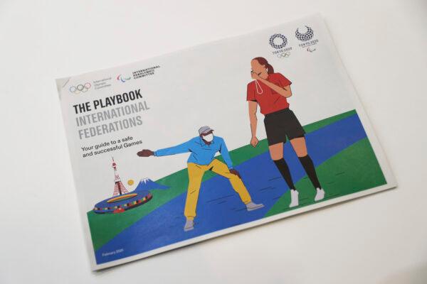 The first version of "The Playbooks" revealed during a joint press briefing in Tokyo on Feb. 3, 2021. (Du Xiaoyi/Pool Photo via AP)
