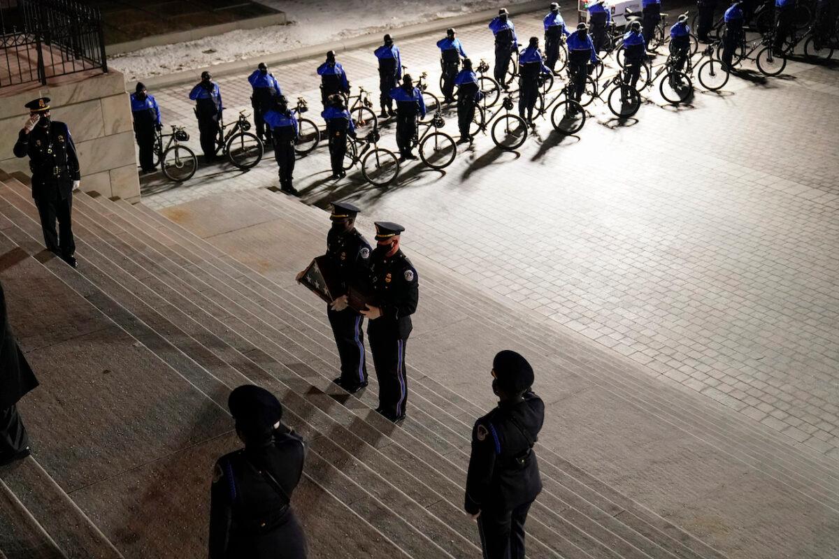 An honor guard carries an urn with the cremated remains of U.S. Capitol Police officer Brian Sicknick and a folded American flag up the steps of the U.S. Capitol to lie in honor in the Rotunda, in Washington, on Feb. 2, 2021. (Alex Brandon/ Pool/AP Photo)