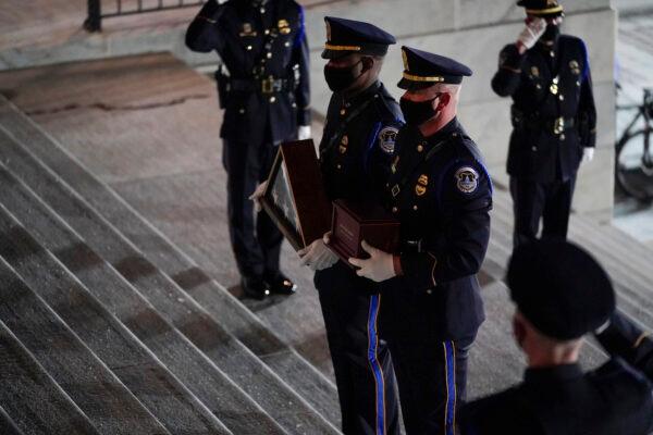 An honor guard carries an urn with the cremated remains of U.S. Capitol Police officer Brian Sicknick and folded flag up the steps of the U.S Capitol to lie in honor in the Rotunda, in Washington, on Feb. 2, 2021. (AP Photo/Alex Brandon, Pool)