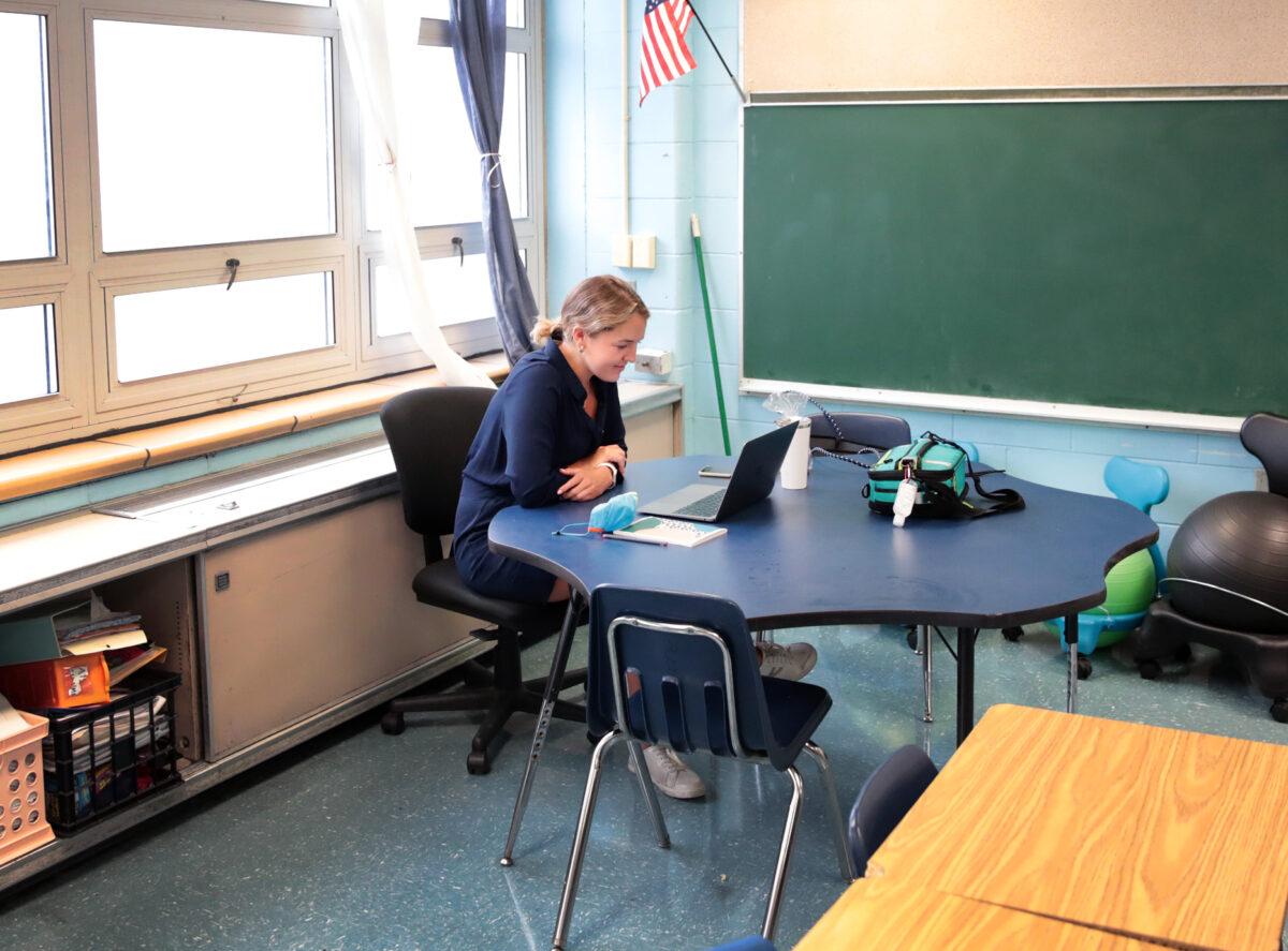 A teacher at King Elementary School sits in an empty classroom teaching her students remotely during the first day of classes in Chicago on Sept. 8, 2020. (Scott Olson/Getty Images)