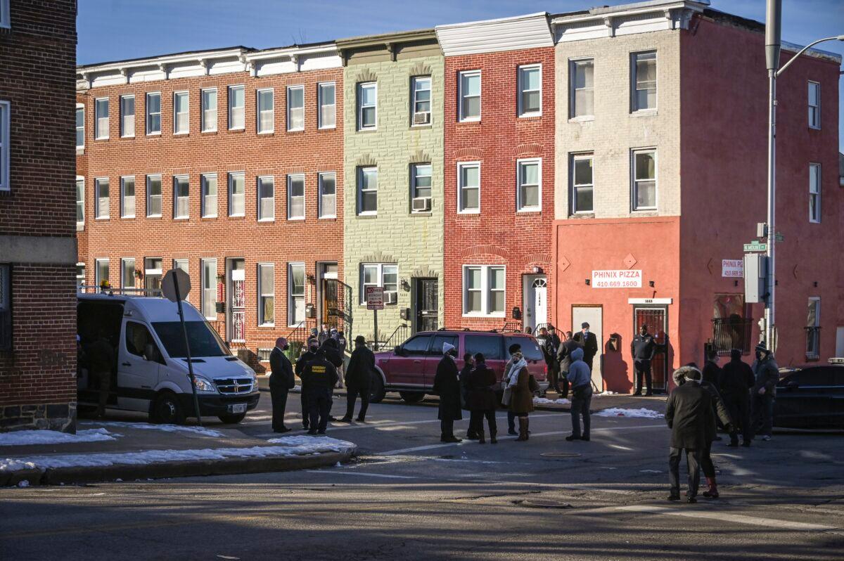 Police officials stand outside a home on N. Mount Street where a U.S. Marshall was shot while while serving an arrest warrant in West Baltimore on Feb. 4, 2021. (Jerry Jackson/The Baltimore Sun via AP)
