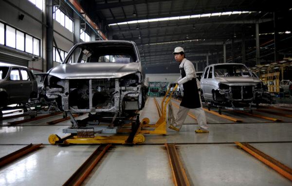 An employee pushes a car along a Zotye Automobile Co., Ltd assembly line in Jinhua, Zhejiang province on April 3, 2013. (Lang Lang/Reuters)