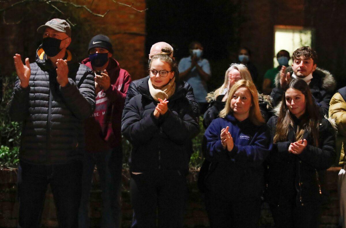 Residents participate in a national clap for late Captain Sir Tom Moore and all NHS workers, amidst the COVID-19 outbreak, in Marston Moretaine, near Milton Keynes, Britain, on Feb. 3, 2021. (Andrew Couldridge/Reuters)