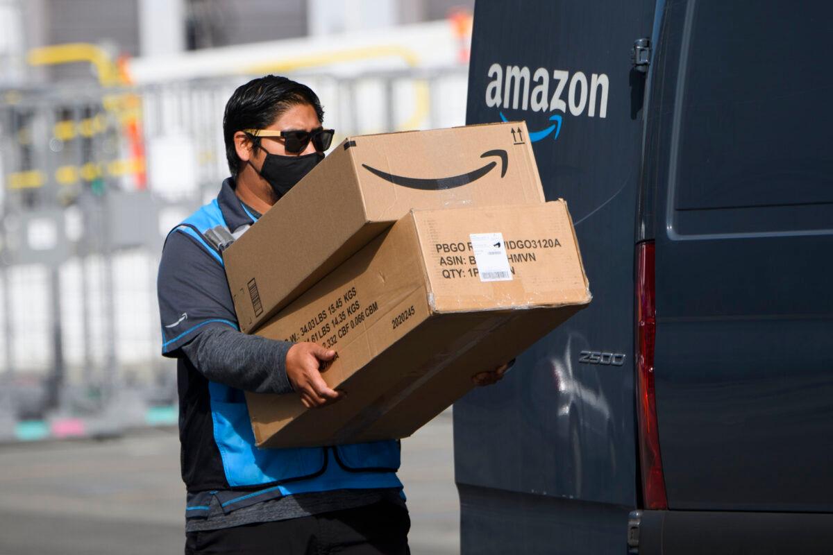 An Amazon.com Inc. delivery driver carries boxes into a van outside of a distribution facility in Hawthorne, Calif., on Feb. 2, 2021. (Patrick Fallon/AFP via Getty Images)