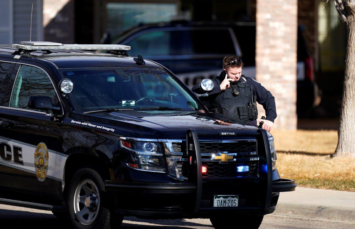 A police officer talks on a mobile device outside the Legacy Assisted Living at Lafayette care facility, in Lafayette, Colo., on Wednesday, Feb. 3, 2021. (David Zalubowski/AP Photo)