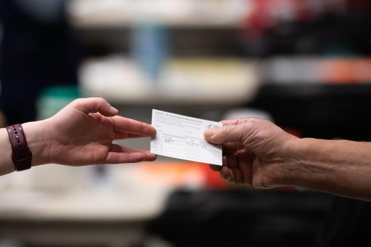 A patient receives a card showing when they received their first dose of the Pfizer COVID-19 vaccine at the Amazon Meeting Center in downtown Seattle, on Jan. 24, 2021. (Grant Hindsley/AFP via Getty Images)