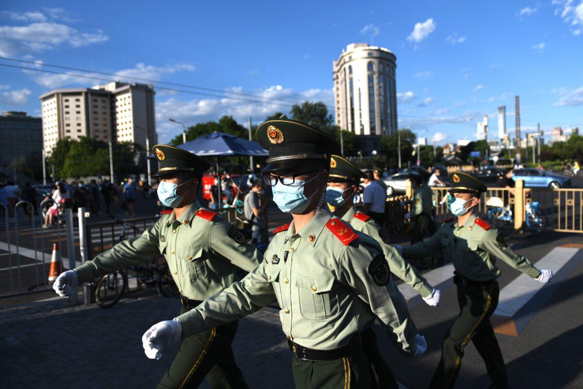 Paramilitary police officers patrol along a street after the closing session of the Chinese People's Political Consultative Conference (CPPCC) in Beijing on May 27, 2020. (Greg Baker/AFP via Getty Images)