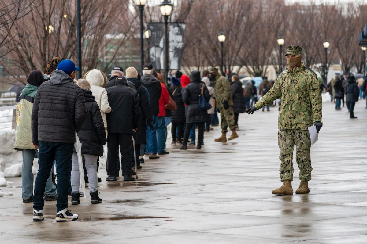 A member of the National Guard gives people direction standing in line at a COVID-19 vaccination site at Yankee Stadium, in the Bronx borough, N.Y., on Feb. 5, 2021. (Mary Altaffer/AP Photo)